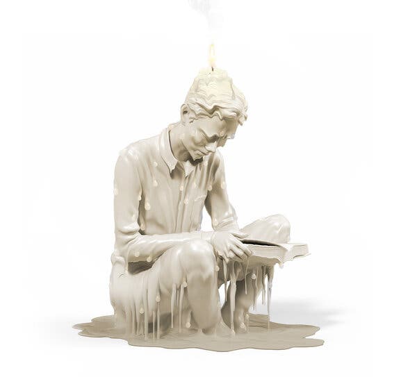 This image shows a beige candle in the shape of a seated man reading a book. A flame emerges from a wick at the top of his skull, and molten wax is accumulating around him as he and his book slowly melt.
